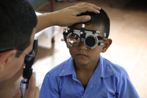 20141111111645-Fudem20 A child with a phoropter has his eyes checked by an optometrist vision care specialist